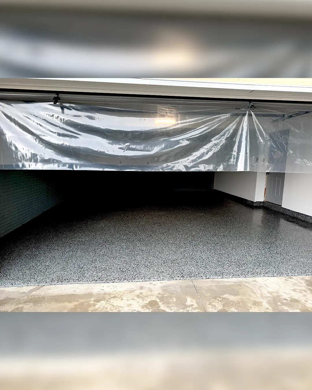 Finished flake epoxy garage floor viewed from the entrance in Iowa